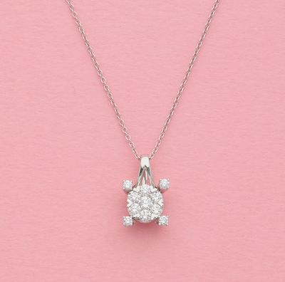un pendentif en forme de tortue en diamant blanc, suspendu à une chaîne, sur fond rose