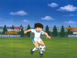 Image d'anime représentant un jeune garçon en train de frapper un ballon de foot sur un terrain