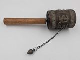 an old metal bell with a wooden handle and a chain around it