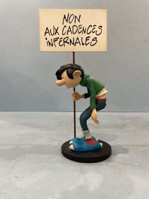 figurine of a man holding a sign that says mon aux cadances infernales