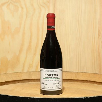a bottle of wine sitting on top of a barrel