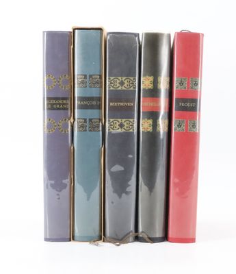trois livres sont empilés sur une surface blanche