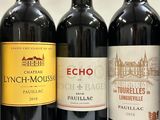 three bottles of red wine are lined up on a table