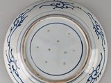 a blue and white plate on a white table