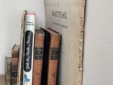 many books on a wooden shelf next to a book case