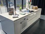 a kitchen with a stove, oven, sink and a window