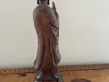 wooden statue of a person on a table with a white background
