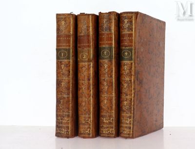 trois vieux livres posés l'un sur l'autre sur une table