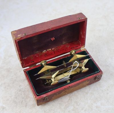 une petite boîte en bois contenant une paire de ciseaux