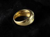 a close up of a gold ring on a black cloth
