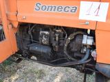 a picture of a tractor that is parked in the grass
