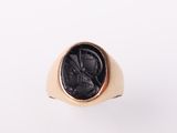 a gold signet ring with a black stone in the center