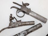 three old guns are laying on a white surface next to a pair of scissors