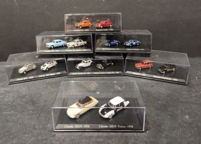 six modèles réduits de voitures différents dans une vitrine posée sur une table