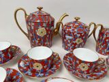 a red and blue tea set on a white table