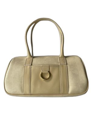 a white purse with a gold ring on the handle