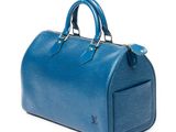 a blue louis vuitton speedy bag on a white background
