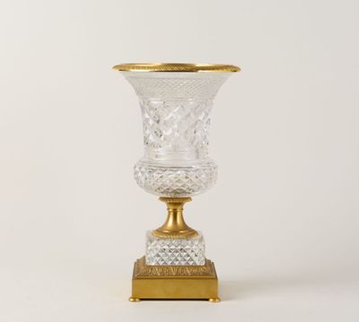 un vase en verre à bord doré posé sur une table