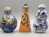 trois vases de couleurs différentes sont alignés sur une surface blanche