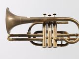 a brass trumpet that is sitting on a white surface