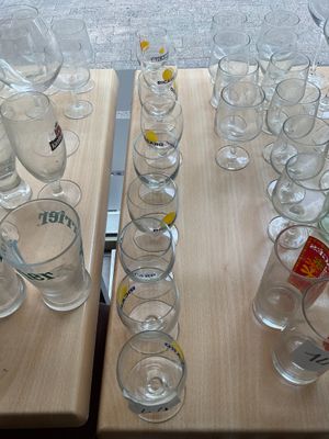 bottles and glasses on a table with a laptop in the background