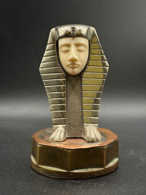 un gros plan d'une statue représentant une tête égyptienne posée sur un socle