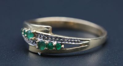 une image montrant un gros plan d'une bague en or sertie d'émeraudes