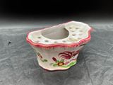 un petit vase orné d'un motif rouge et blanc