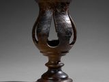 a brown vase that has a hole in the middle of it
