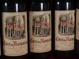 several bottles of red wine are lined up on a table