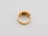 a close up of a gold ring on a white surface