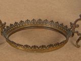 an image of a metal crown on a table with a brown background