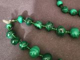 necklace and bracelet with green beads on a brown cloth