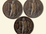 three bronze coins with a statue of a woman and a man on them