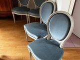 four blue chairs in a row in a room with a wooden floor