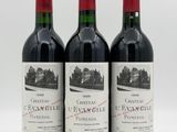 three bottles of red wine sitting next to each other on a white surface