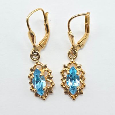 une paire de boucles d'oreilles en topaze bleue sur fond blanc
