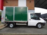 a white truck with a green door parked in front of a building