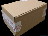 a cardboard box with a sticker on it on a black background