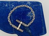 un gros plan d'un bracelet orné d'une croix posée sur une pierre bleue