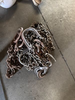 a pile of chains on the ground next to a pair of shoes