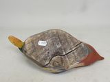 a small wooden turtle sitting on top of a piece of wood