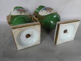 three green and white vases sitting on top of a table