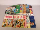 several children ' s books are lined up on a white surface