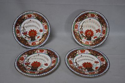 four plates with floral designs on them sitting on a table