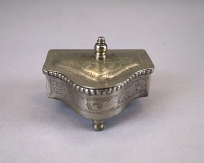 an old silver box with a lid sitting on a table