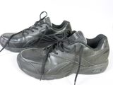 une paire de chaussures noires posées sur une surface blanche