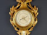 une horloge en or sur le mur avec un oiseau dessus