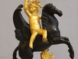 une statue représentant un enfant à cheval sur une horloge