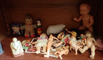 une étagère sur laquelle sont posées plein de poupées et de jouets